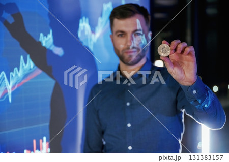 Digital currency, holding coin in hand. Business coach against projector with data Digital currency, holding coin in hand. Business coach against projector with data 131383157