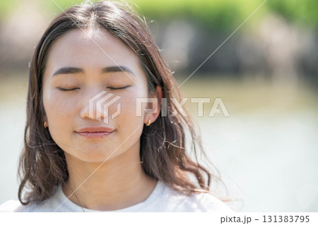 川辺で寛ぐ女性 131383795