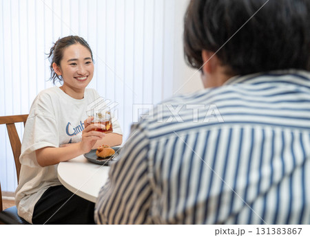 部屋の中で会話しながら食事を楽しむ男女 部屋の中で会話しながら食事を楽しむ男女 131383867