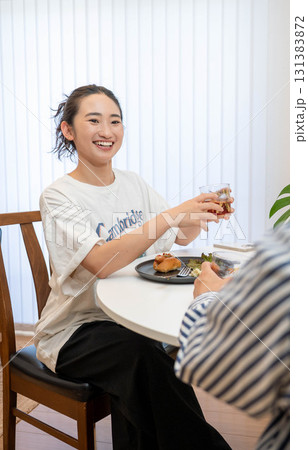 部屋の中で会話しながら食事を楽しむ男女 部屋の中で会話しながら食事を楽しむ男女 131383872