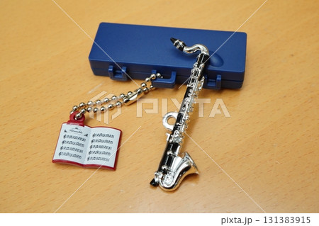 ミニチュアのバスクラリネットとケースと楽譜キーホルダーを並べたかわいい小物写真 131383915