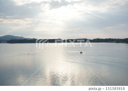 朝の柔らかな光が差し込む湖面に小舟が浮かぶ幻想的で静かな浜名湖の風景 朝の柔らかな光が差し込む湖面に小舟が浮かぶ幻想的で静かな浜名湖の風景 131383918