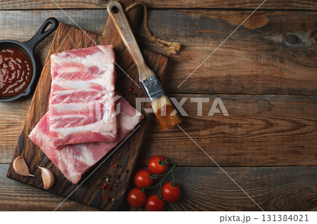 Raw pork ribs with spices, salt and rosemary on dark wooden background 131384021