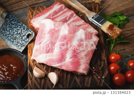Raw pork ribs with spices, salt and rosemary on dark wooden background 131384023