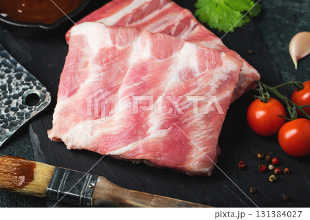 Raw meat. Raw pork ribs from the back with meat on a black background. background image 131384027