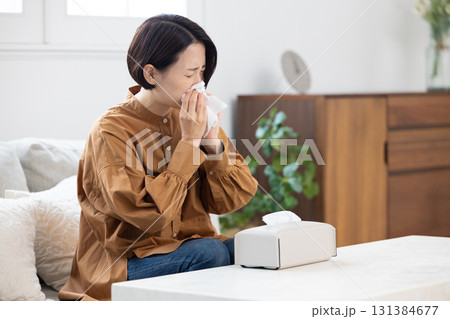 辛そうに鼻をかむミドル女性 131384677