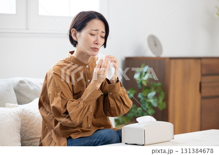 辛そうに鼻をかむミドル女性 131384678