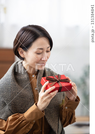 プレゼントボックスを手に微笑むミドル女性 131384841