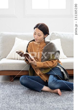 自宅のリビングルームで読書を楽しむミドル女性 131385190