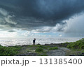 悪天候の海を見て悩む男性 131385400