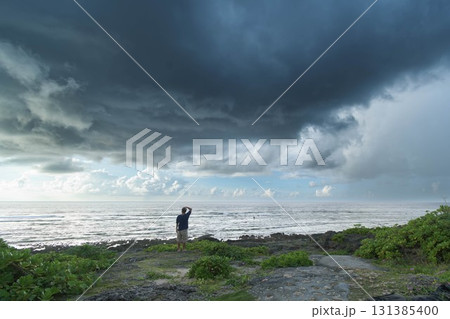 悪天候の海を見て悩む男性 悪天候の海を見て悩む男性 131385400