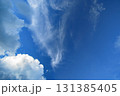雲のある青空にさらに高く飛行機雲 131385405