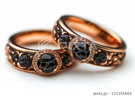 Pair of gold wedding rings with a skull pattern on a white background. Original style. Pair of gold wedding rings with a skull pattern on a white background. Original style. 131385668