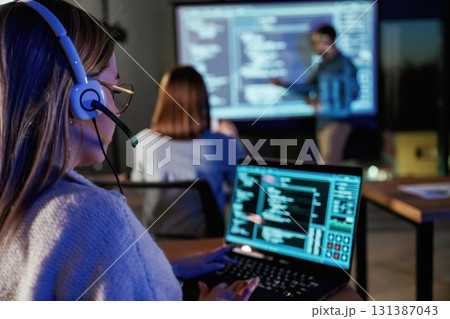 Audience is with laptops. Male business trainer is against projector with data, teaching people 131387043