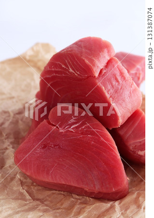 Tuna slices on white plate. Steaks from fresh tuna fillet. An isolated object. White background.Close-up.Vertical photo. Tuna slices on white plate. Steaks from fresh tuna fillet. An isolated object. White background.Close-up.Vertical photo. 131387074