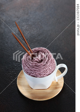 Yarn made from pure wool for knitting. Ball of yarn in cup. Concept of hobbies and handicrafts. Yarn made from pure wool for knitting. Ball of yarn in cup. Concept of hobbies and handicrafts. 131387084