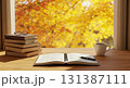 秋の雰囲気に包まれた木製デスクの本とコーヒーカップ 131387111