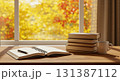 秋の雰囲気に包まれた木製デスクの本とコーヒーカップ 131387112