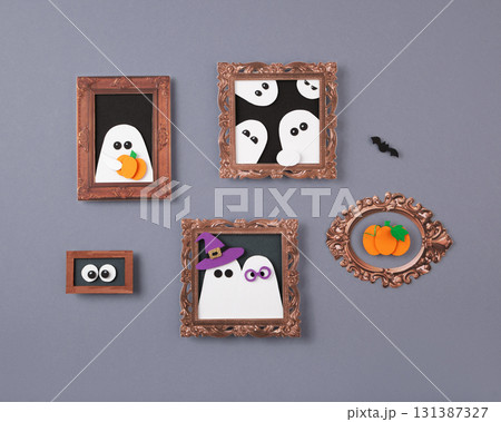 Halloween paper crafts featuring framed ghosts, pumpkins, and eyes on a gray background Halloween paper crafts featuring framed ghosts, pumpkins, and eyes on a gray background 131387327