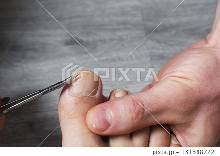 Shaving her toenails with scissors close-up 131388722