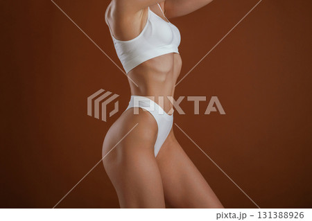 Fashion model. Woman with slim body shape is posing against background Fashion model. Woman with slim body shape is posing against background 131388926