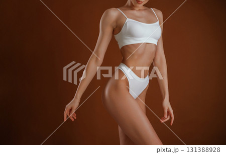 Fashion model. Woman with slim body shape is posing against background Fashion model. Woman with slim body shape is posing against background 131388928