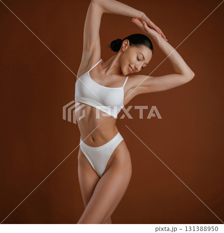 Showing brand new underwear. Woman with slim body shape is posing against background 131388950