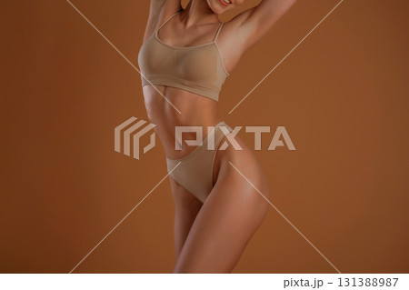 Close up view. Woman with slim body shape is posing against background Close up view. Woman with slim body shape is posing against background 131388987