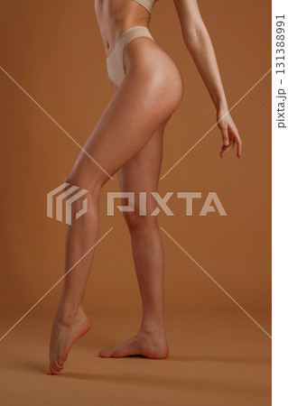 Showing the side, standing. Woman with slim body shape is posing against background 131388991