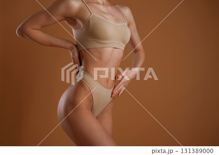 Fitness slim body shape. Woman is posing against background Fitness slim body shape. Woman is posing against background 131389000