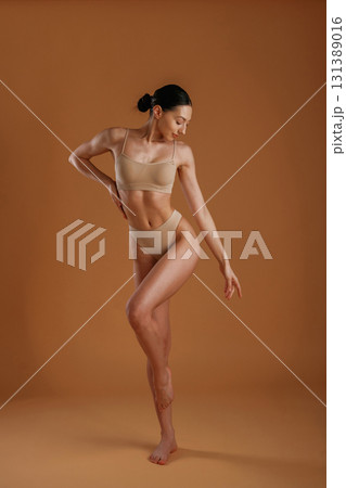 Beautiful model. Woman with slim body shape is posing against background Beautiful model. Woman with slim body shape is posing against background 131389016