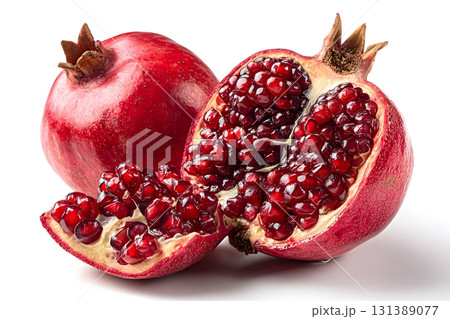 A red pomegranate fruit cut open shows its seeds isolated on a white background. 131389077
