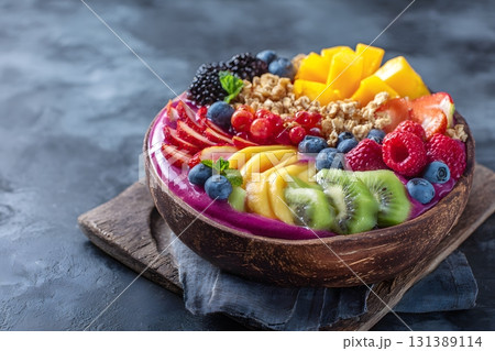 Fruit bowl ready to eat with fresh berries and granola on a dark background. 131389114