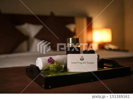 Cozy hotel room with sleep program amenities on a tray for restful sleep experience Cozy hotel room with sleep program amenities on a tray for restful sleep experience 131389161