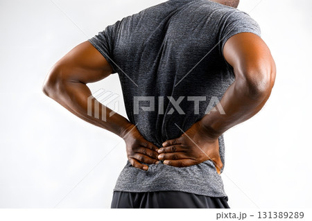 Person holds aching lower back in pain. 131389289