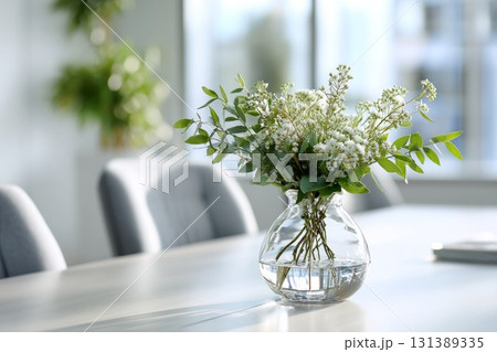 Elegant desk plant decor with fresh flowers in a clear vase enhancing modern workspace ambiance Elegant desk plant decor with fresh flowers in a clear vase enhancing modern workspace ambiance 131389335