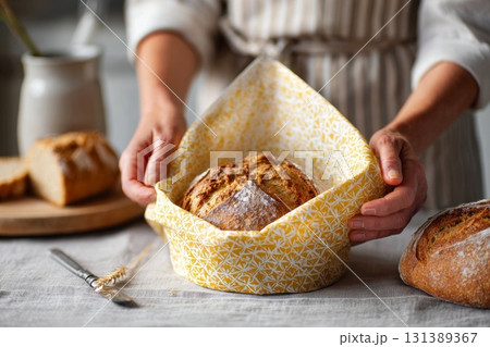 Reusable beeswax wraps showcasing fresh bread in a cozy kitchen setting with natural textures 131389367