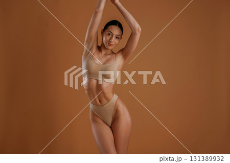 Beautiful model. Woman with slim body shape is posing against background 131389932