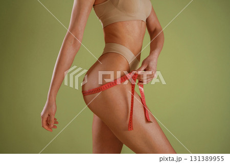 Woman with slim body shape is posing against background Woman with slim body shape is posing against background 131389955