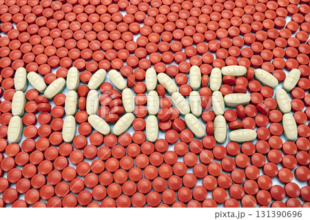White pills spelling MONEY on background of red pills, creating striking contrast. arrangement is creative and visually engaging, highlighting themes of health and finance 131390696