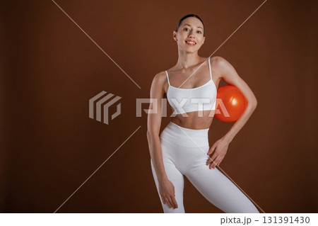 With red ball. Beautiful fitness woman is in the studio 131391430