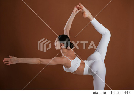 In white clothes. Beautiful fitness woman is in the studio In white clothes. Beautiful fitness woman is in the studio 131391448