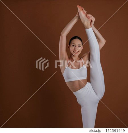 In white clothes. Beautiful fitness woman is in the studio 131391449