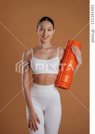 Against brown background. Beautiful fitness woman is in the studio Against brown background. Beautiful fitness woman is in the studio 131391485