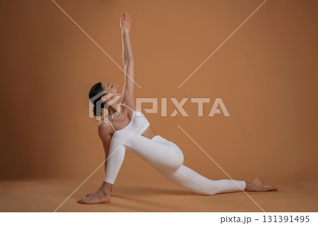 Doing stretching exercises. Beautiful fitness woman is in the studio 131391495