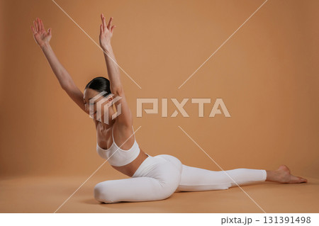 Amazing stretch. Beautiful fitness woman is in the studio Amazing stretch. Beautiful fitness woman is in the studio 131391498