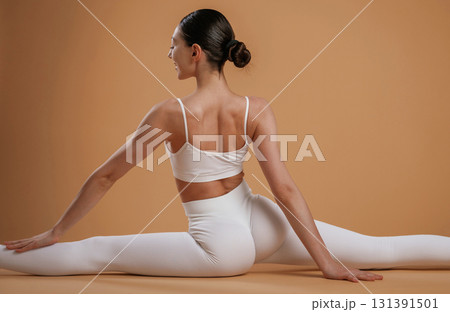 Sitting on twine. Beautiful fitness woman is in the studio 131391501