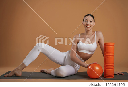 On the floor, sitting. Beautiful fitness woman is in the studio 131391506