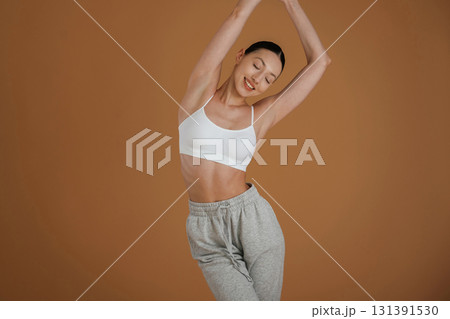 Female, front view, smiling. Beautiful fitness woman is in the studio Female, front view, smiling. Beautiful fitness woman is in the studio 131391530