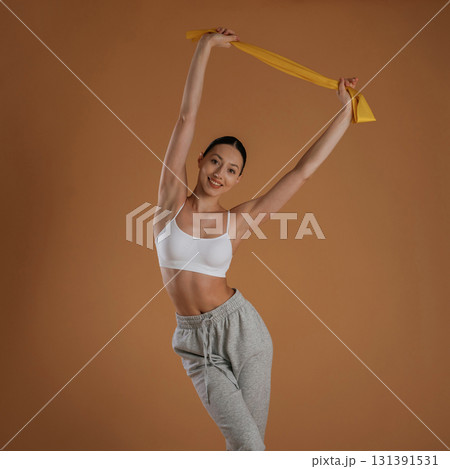 Cloth for stretching hands. Beautiful fitness woman is in the studio Cloth for stretching hands. Beautiful fitness woman is in the studio 131391531